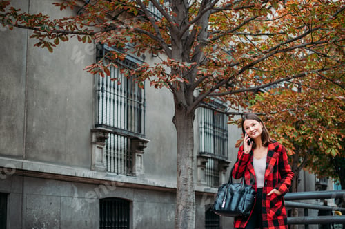 Preview: pretty young woman walking on the street using smartphone