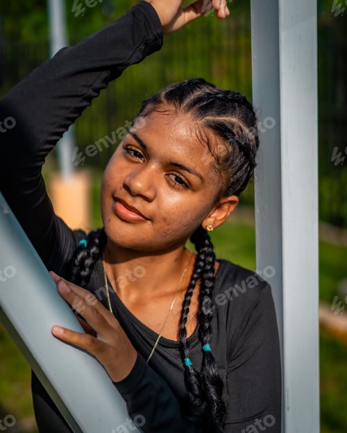 Preview: Vertical of a beautiful young woman in a black shirt posing outdoors