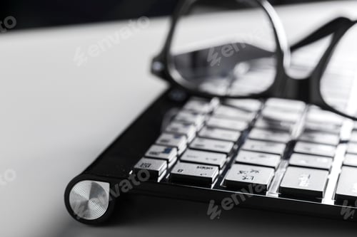Preview: eyeglasses and keyboard on the table