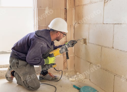 Preview: Craftman drilling a hole with a pneumatic hammer drill perforator in a brick wall