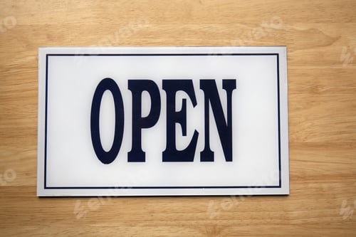 Preview: Overhead shot of a white sign with closed written on it placed on a wooden surface