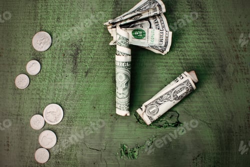 Preview: Money flat lay dollar bills and spare change on Green rustic wood background