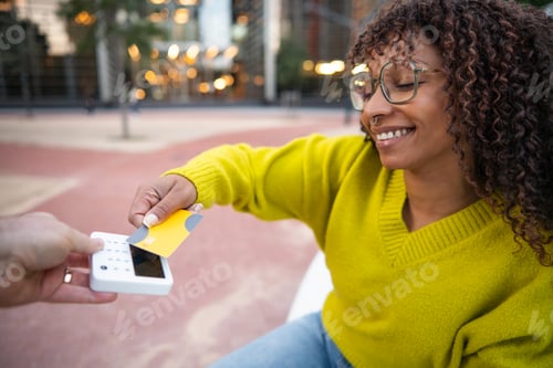 Preview: Smiling woman making cashless payment with credit card