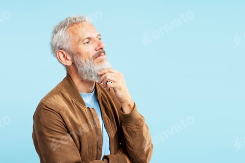Preview: Pensive mature man touching his beard, planning project looking away isolated on blue background