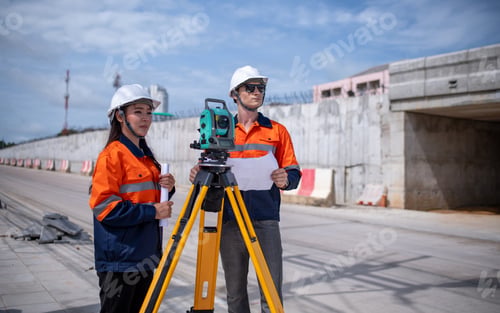 Preview: Engineers Surveyor wearing safety uniform ,helmet with equipment theodolite to measurement positioni