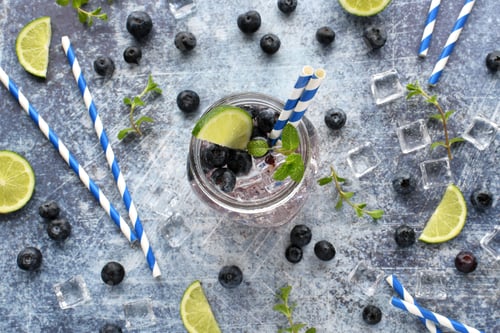 Preview: Refreshing blueberry lime mint spa water on blue slate background. Overhead flat lay,.