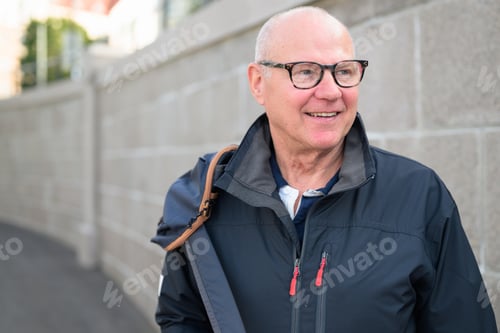 Preview: Portrait of a smiling senior man wearing glasses and a jacket.