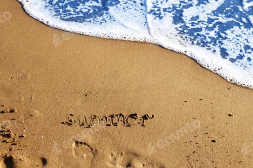 Preview: the word summer handwritten on the sandy beach and footprint with wave and copy space