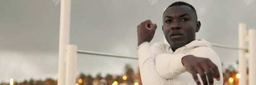 Preview: Athlete warming up for a street workout in the evening. Panoramic
