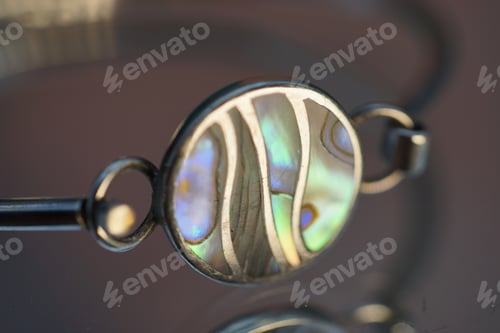 Preview: an oval - shaped glass bang necklace with silver, black, and green gems