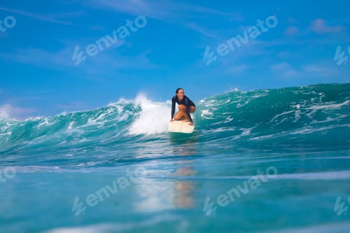 Preview: Female surfer on a blue wave