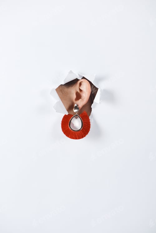 Preview: cropped image of woman with beautiful luxury red earring standing in hole of white paper