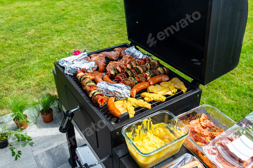 Preview: A modern rectangular grill standing on a paving slab on a garden terrace.