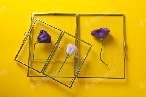 Preview: Fresh flowers and glass frames on yellow background, top view