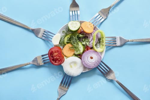 Preview: Top view of sliced pieces of fresh vegetables and spices on forks