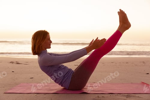 Preview: Woman performing yoga on the beach during sunset