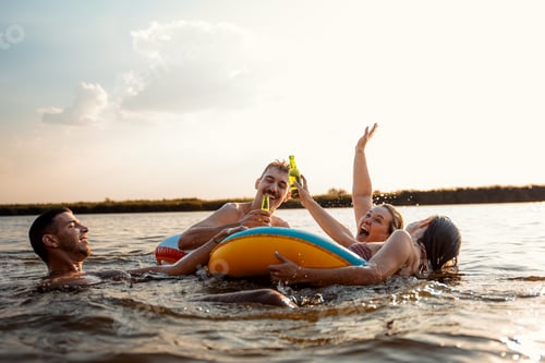 Preview: Group of friends having fun and enjoying a summer day swimming with rubber tube.