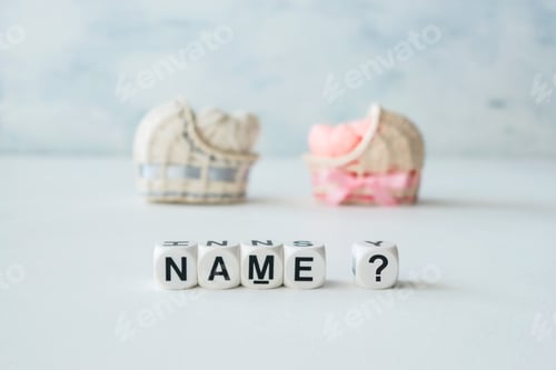 Preview: Concept of choosing baby name. Pink and blue decorative straw cradles with thread hearts and text