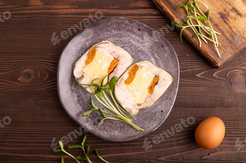Preview: Chicken, egg and dried apricot meatloaf, microgreen on brown wooden.