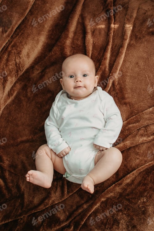 Preview: Organic cotton newborn baby clothes. Cute newborn baby in white bodysuit made of organic cotton