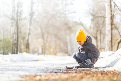 Preview: Child Plays with Paper Boat on a Winter Day