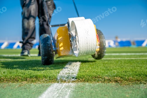 Preview: Lining a football pitch using white paint on grass.