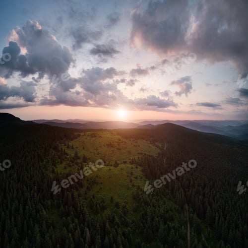 Preview: Beautiful sunset over grassy hill and mountain forest.