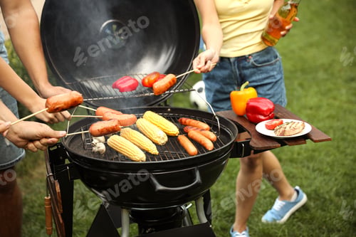 Preview: People with sausages near barbecue grill outdoors, closeup