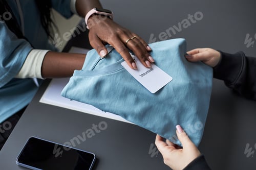 Preview: Handing Over Volunteer Shirt Across Desk
