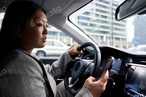 Preview: Chinese woman using mobile phone while driving a car