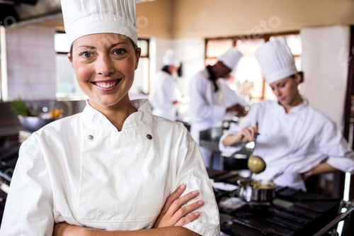 Preview: Female chef standing with arms crossed in kitchen