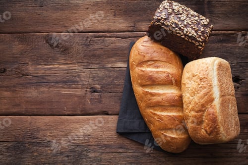 Preview: Different fresh bread, on old wooden table. Top view with copy space