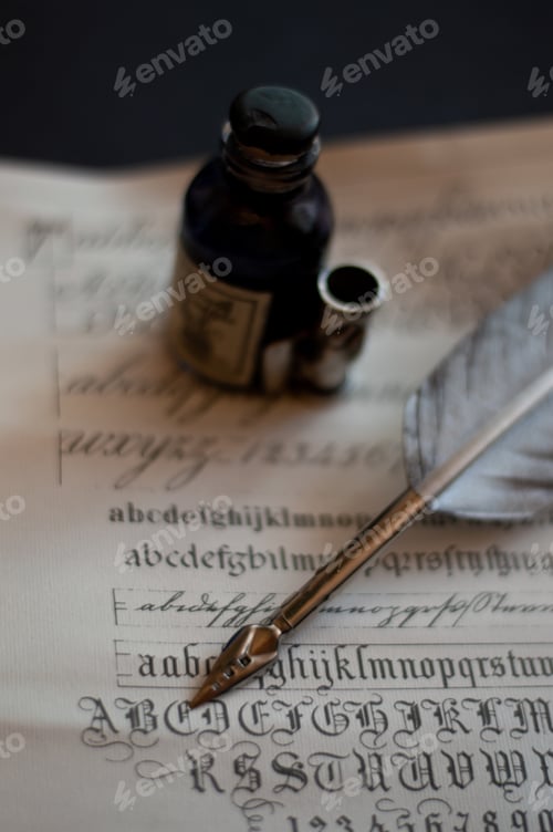 Preview: Vertical shot of a quill set and an ink bottle on a piece of paper with calligraphy on it