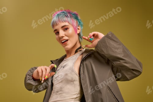 Preview: Young woman joyfully poses in colorful outfit with vibrant dyed hair in studio