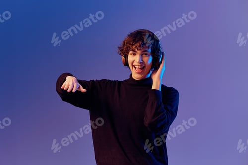 Preview: Male singer wearing headphones listening to music and singing with his mouth open, recording studio