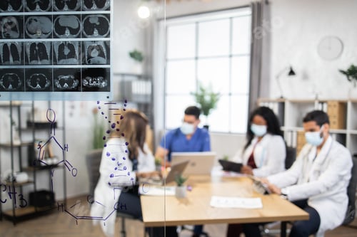 Preview: Blurred view of multiethnic team of doctors, sitting at the table and working on computers and