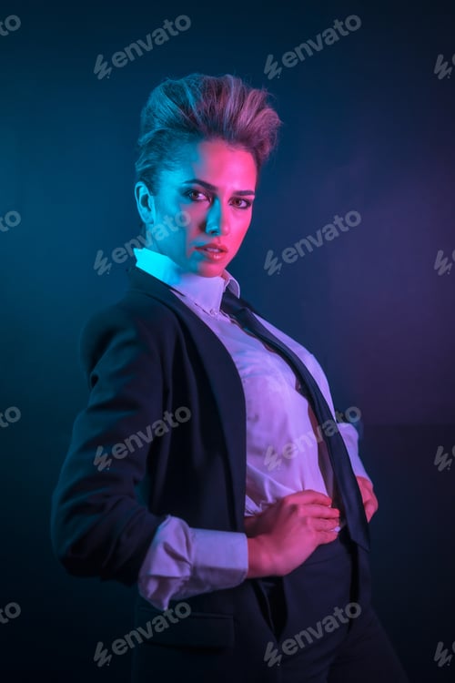 Preview: Sexy young blonde hair female in a black suit posing in studio