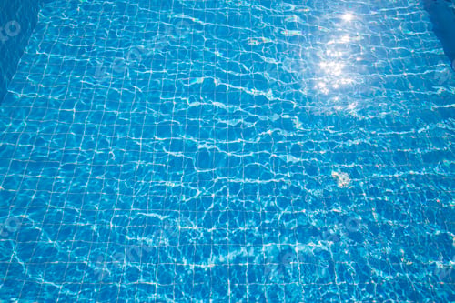 Preview: Clear turquoise pool water reflects sunlight creating a serene outdoor atmosphere perfect for
