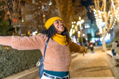 Preview: Happy tourist embracing christmas city lights at night