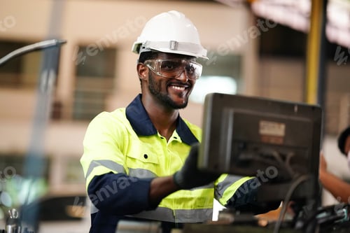 Preview: Closeup side view of early 30's male employee at a factory plant operating a production line machine