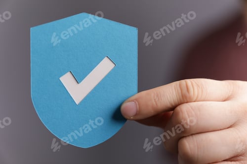 Preview: Sign of the checkmark made of paper in the hands of a man