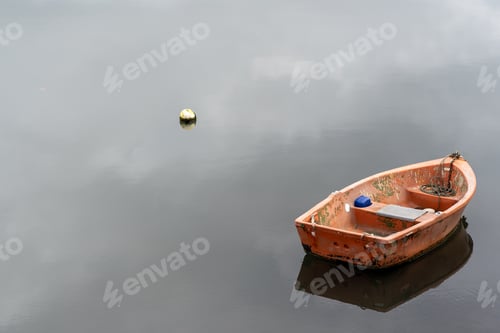 Preview: row boat on calm still lake with boats reflection on water