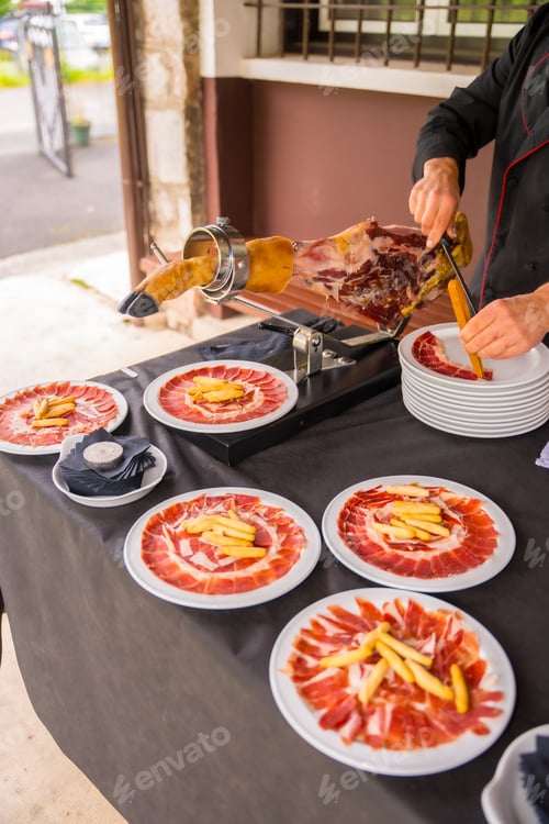 Preview: Detail of a man cutting Iberian ham at a wedding or event. Service of a person cutting a piece