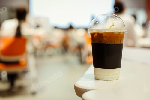 Preview: Close up glass of ice latte with blurred people in business workshop and presentation.
