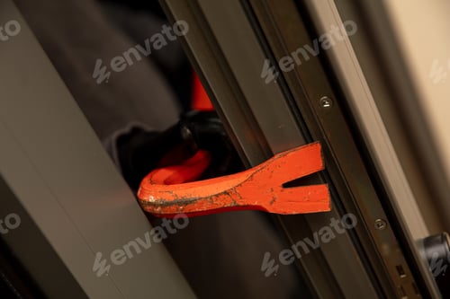 Preview: Housebreakery with a crowbar, breaking a aluminum window.