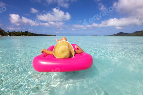 Preview: Woman floating over tropical island turquoise ocean water