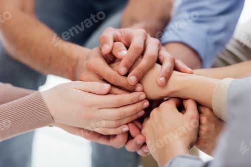 Preview: cropped view of people stacking hands during group therapy session