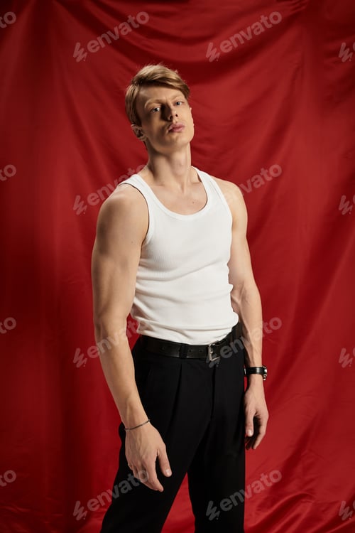 Preview: Young man exuding confidence and style against a bold red backdrop