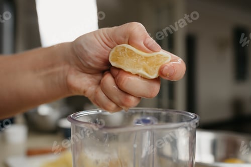 Preview: A Close Photo From The Side Of The Hand Of A Woman Who Is Crushing Lemon Juice By The Hand Into The