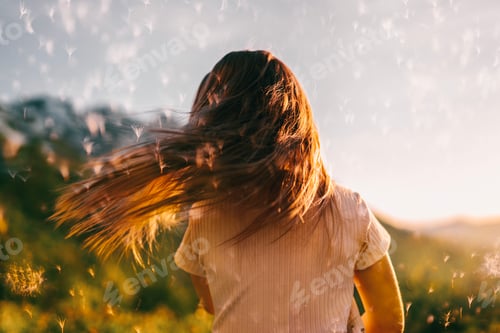 Preview: A little girl dances at sunset in the mountains against the background of a flying dandelion